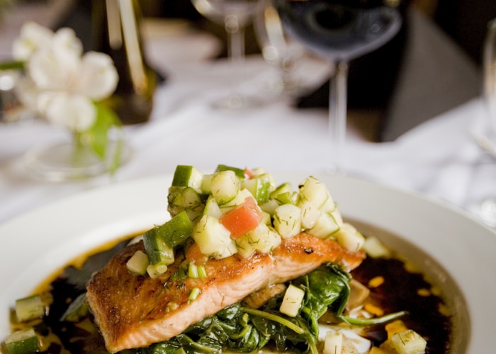 Varm middag med ovnsbakt kylling og rotgrønnsaker på trefjøl, kveldslys